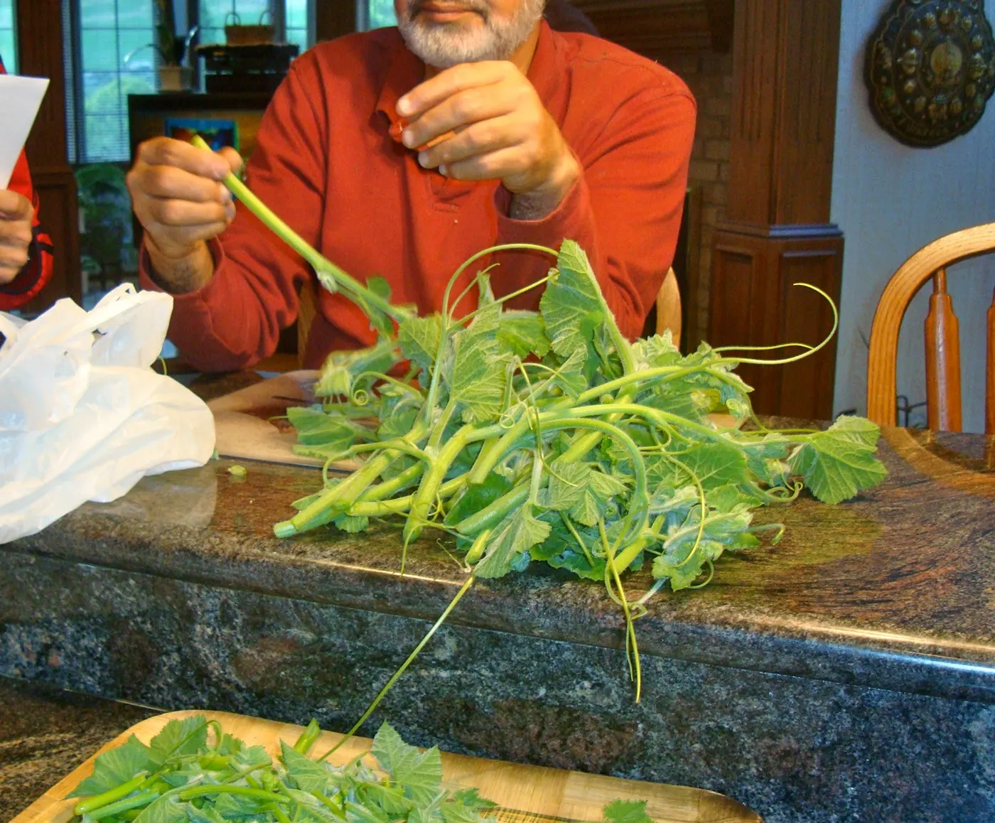 Picking through and discarding any tough, large stems and matured leaves from the vine shoots and using only young shoots and tender leaves.