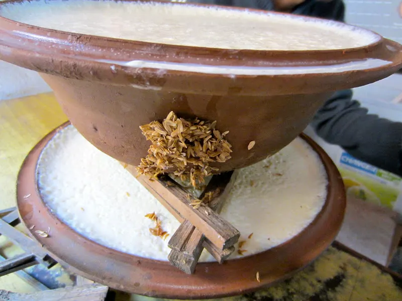 Voila! Juju Dhau is ready to be placed in the shelves to rest. Some of the rice husk that are attached to the container have to be removed. The triangle wood stand is called dhauka, which help to keep the container stacked up.