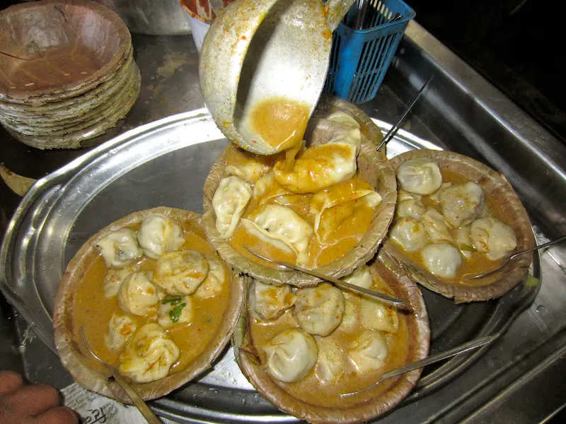 Serving momo (bite-size dumpling filled with meat or vegetables) with sauce in a disposable leak-proof duna bowl.