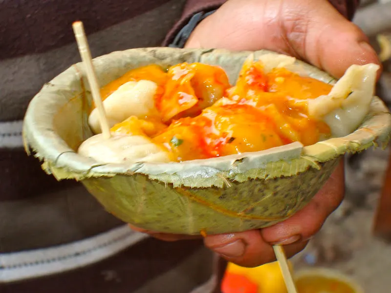 An attractive machine-made leaf bowl with freshly steamed momo with tomato chutney.