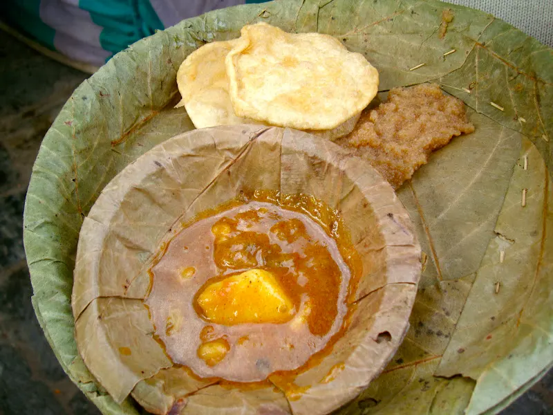During the auspicious festival of Shivaratri - dry saal leaf plates are used to distribute food (poori, haluwa and aloo tarkari) near Shiva Temple, Hanuman Dhoka area, Kathmandu.