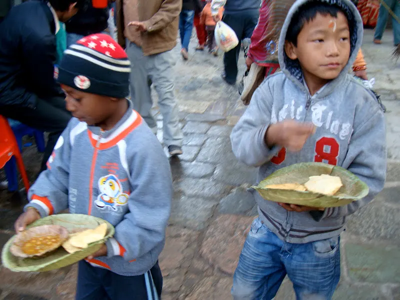 Small children holding and walking the light and flexible leaf plates during the Shivaratri festival feast.