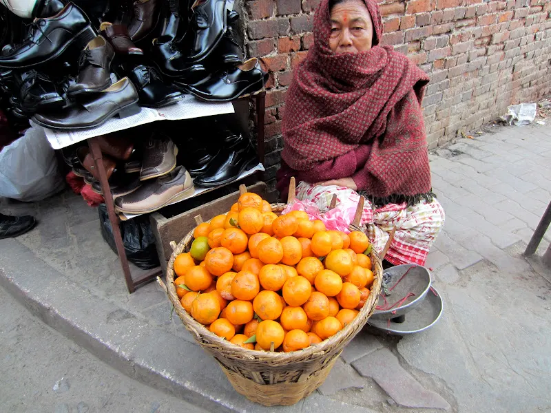 A Suntala (orange) vendor waits for customers at a busy intersection.