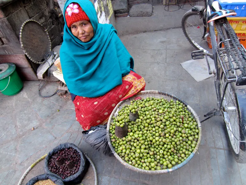 A woman sells freshly picked Thulo Amalaa (Indian Gooseberry) at a corner of a busy Kathmandu market.