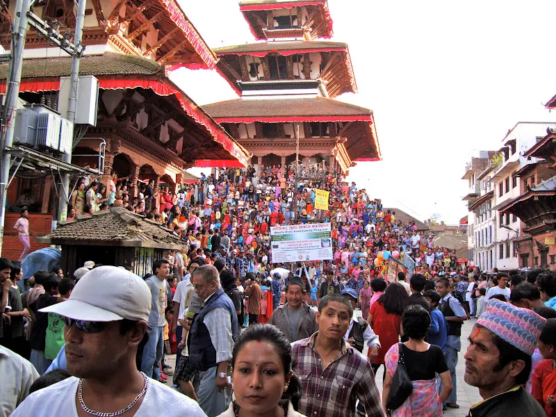 Indra Jatra festival time crowd in Kathmandu - people are celebrating and enjoying the annual festival sitting around the temple steps near Durbar square area.
