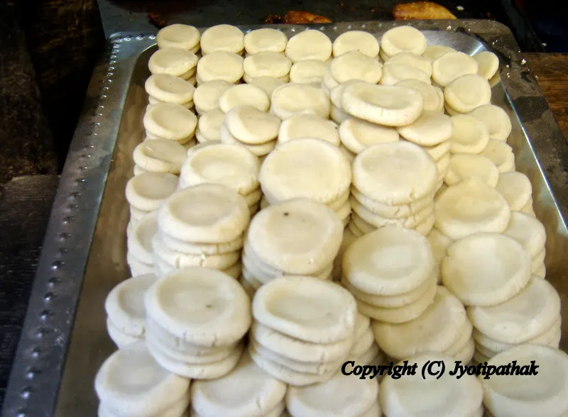 The freshly made Prashad ko Peda प्रशाद को पेडा (made for religious offering) is getting ready to be decorated. A chopped pistachios nuts or sometimes a whole nut is pressed into the center of peda to decorate them.
