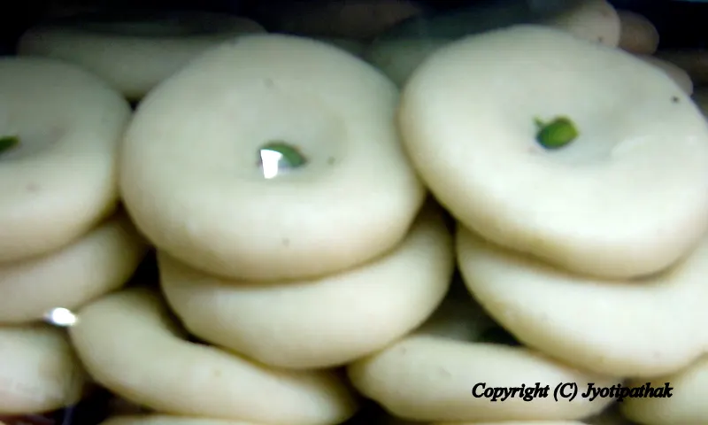 Closed-up look of the Prashad ko Peda - the round patties has a slight depression at the center and it is garnished with chopped pistachios.