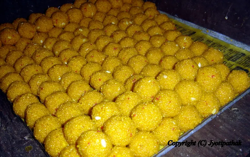 The Haluai Pasale (sweet maker) has carefully placed the sweet laddu on a tray, to harden for a few minutes. It is then transferred to an attractive platter and delivered to the religious function.