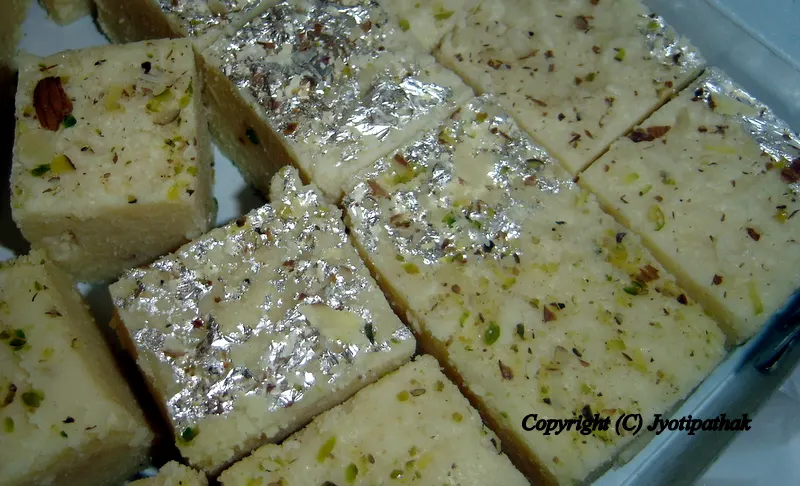 Kalaakand (कलाकंद) - Grainy textured sweets made from whole milk, sugar, flavoring and decorated with chopped pistachios and silver leaf (varak paper).