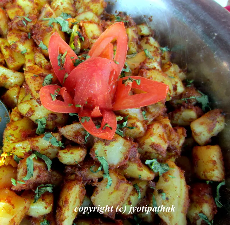 Festive aloo ko achaar served at a Nepali bhoj - with a tomato rose garnish that adds beautiful touch making this dish attractive.