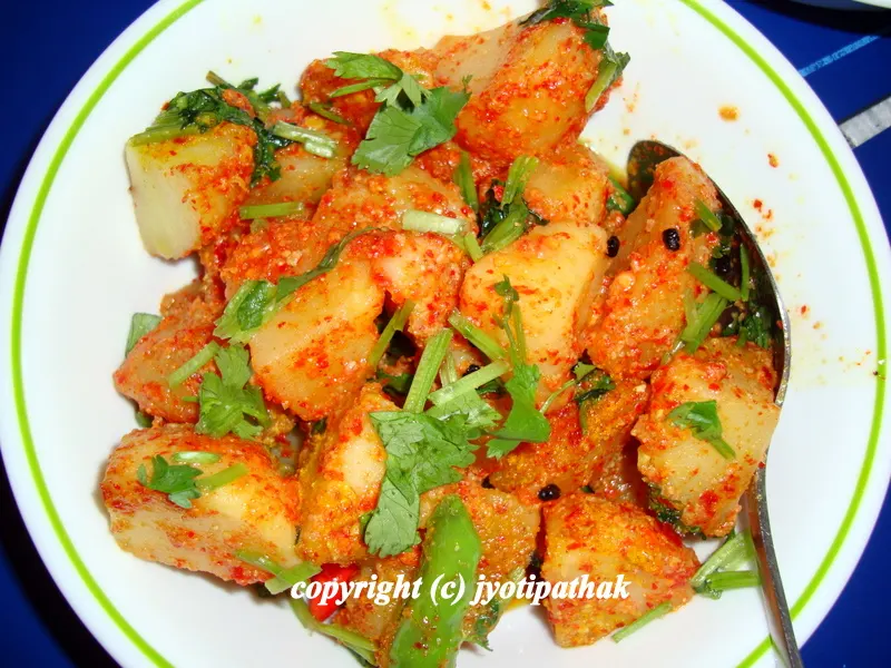 The less spicy version of aloo ko achaar is typically served over a drink as an appetizer. It is a very versatile dish that one can make, and each family has their own version. It is enjoyed leisurely any time of the day.