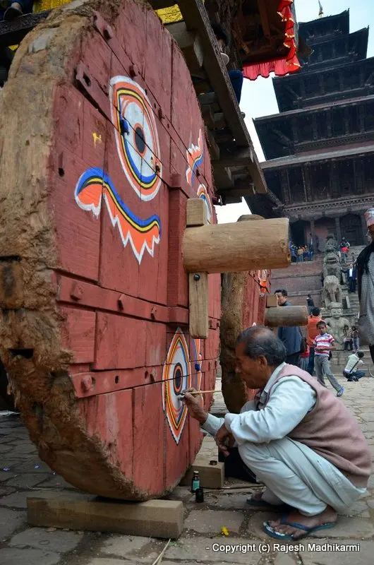... decorating and giving the finishing touch to the big wooden chariot wheels ...