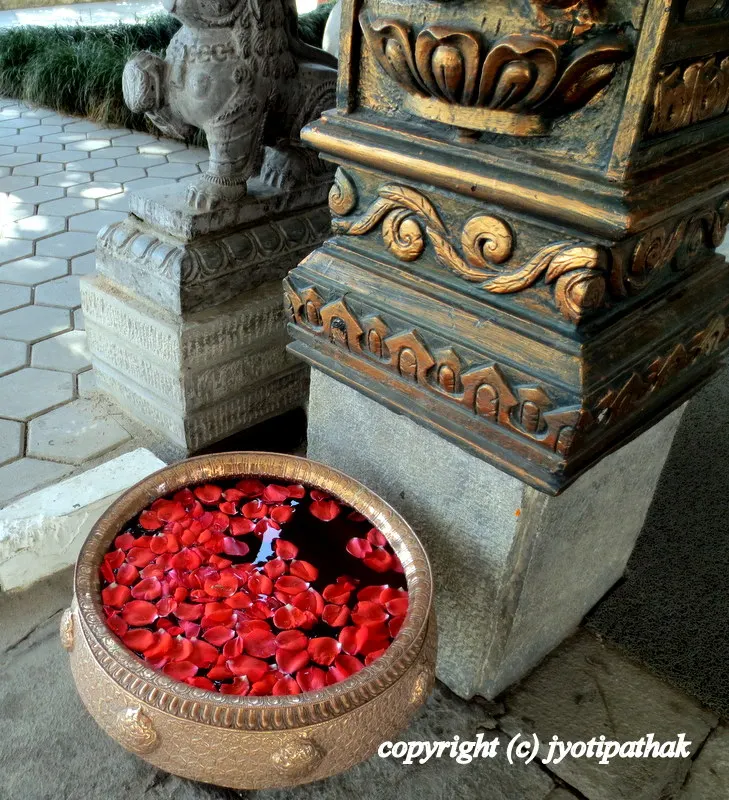 Welcoming visitors with red rose petals filled beautiful hand-crafted brass metal khadkalo pot.