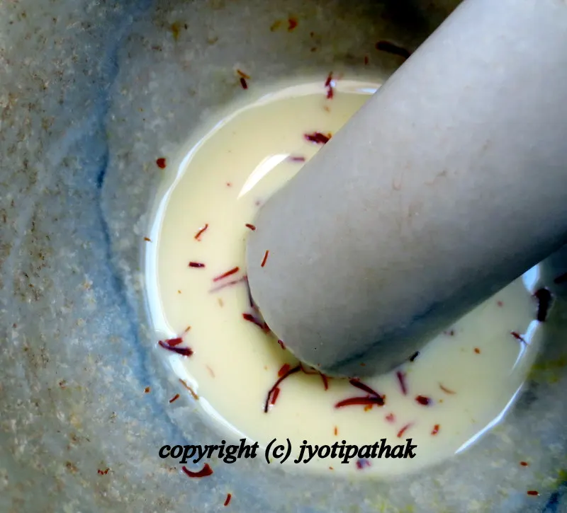 ....saffron strands mixed with warm milk in a mortar and pestle to dissolve, which will impart golden hue and delicious flavor to yogurt dish, sikarni ...