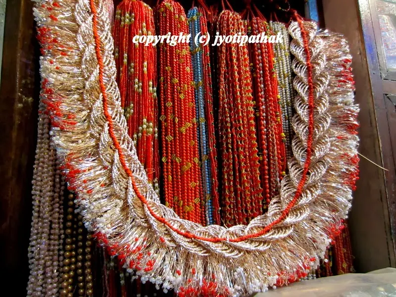 Beautifully hand-crafted zari work design frames are for sale at a store near the hidden alleyways in Indra Chowk, Kathmandu (cokhache galli). It is specially made to give decorative touch to completed dubo ko maalaa.