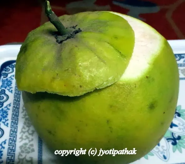 How to peel a pomelo - with a sharp paring knife, slice about 1 ½ inches off from the top end of pomelo or remove the cap off until the flesh is exposed like in the above picture.