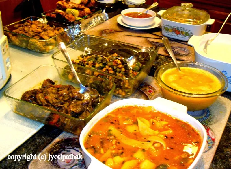 Inviting friends and family and serving Nepali food buffet style for a huge crowd. A large container of bamboo shoots dish in the front of the table.