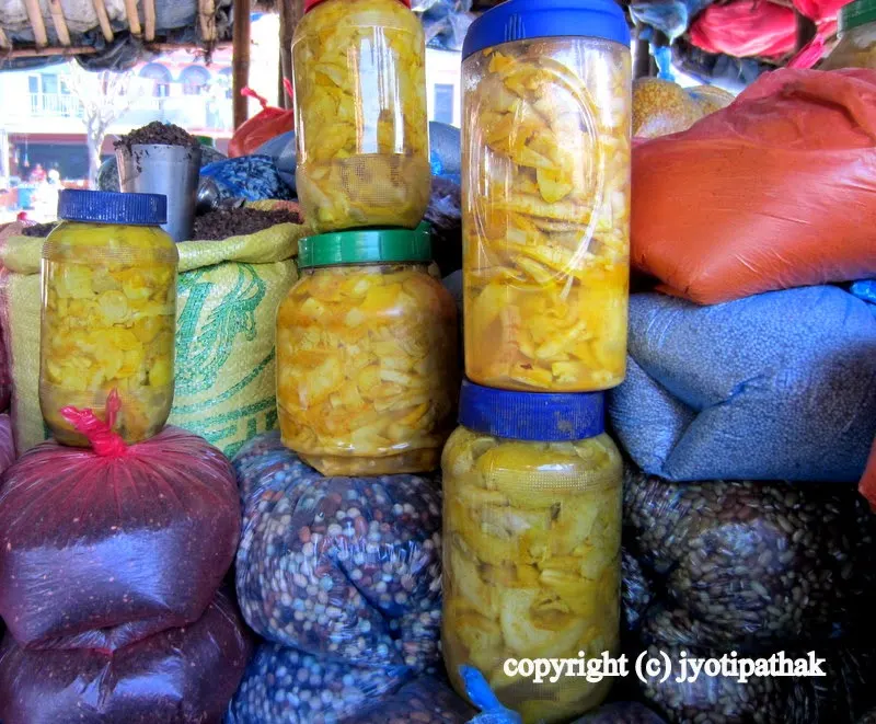 Several bottles of savory, fermented bamboo shoots coated with ground turmeric for sale near Malekhu Bazaar, Nepal. All you need to do is buy and start making your favorite bamboo dish.