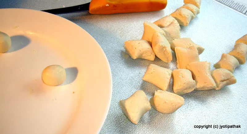 Dividing the dough into 25 equal pieces and rolling each piece into a small ball.